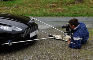 An automobile photographer is capturing a photo of a car logo for promotional activity