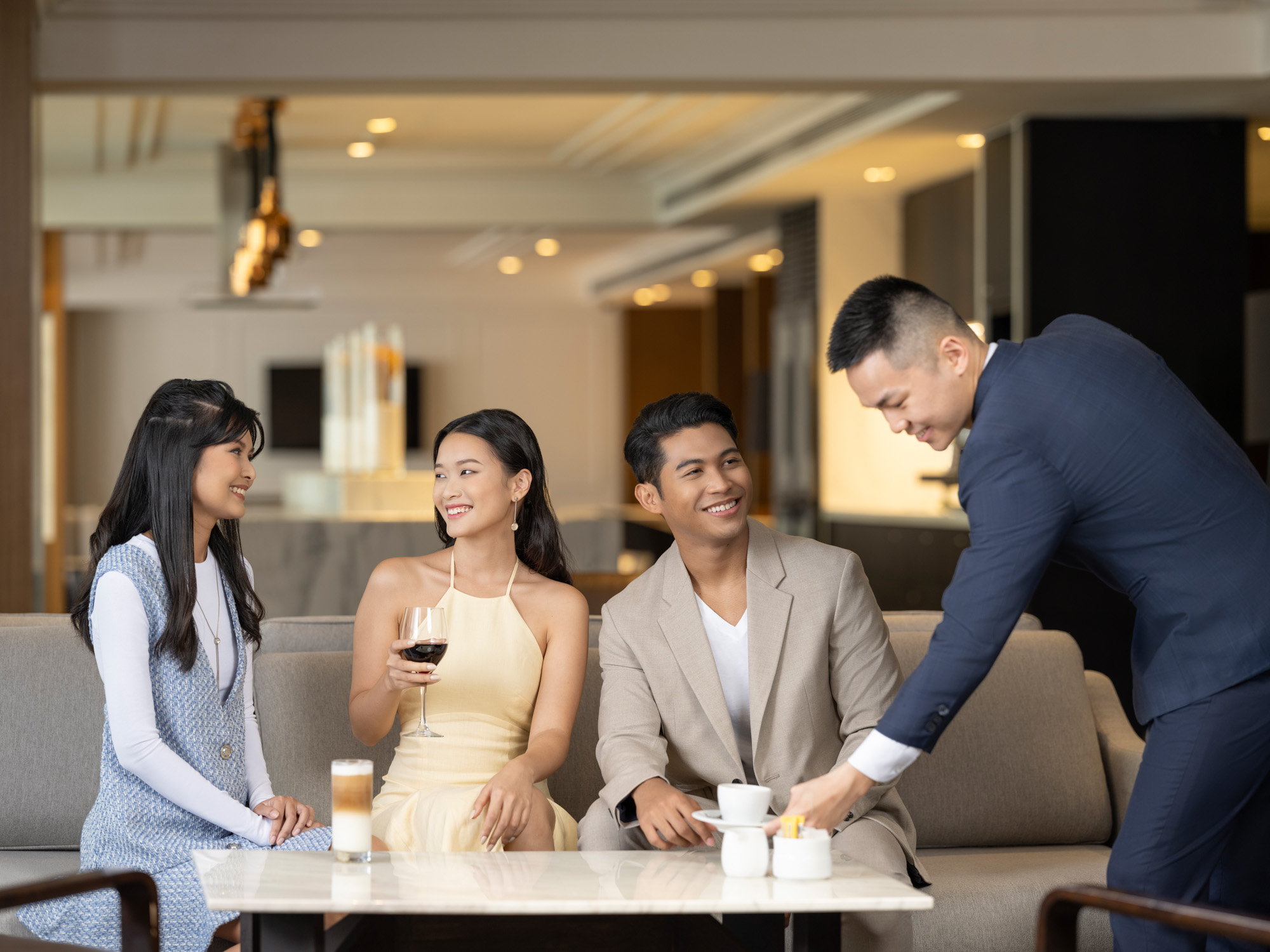 commercial lifestyle photo of group of friends enjoying coffee and wine at the lounge of voco hotel singapore