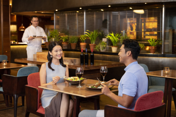 commercial lifestyle photography young couple eating at a restaurant at voco hotel singapore