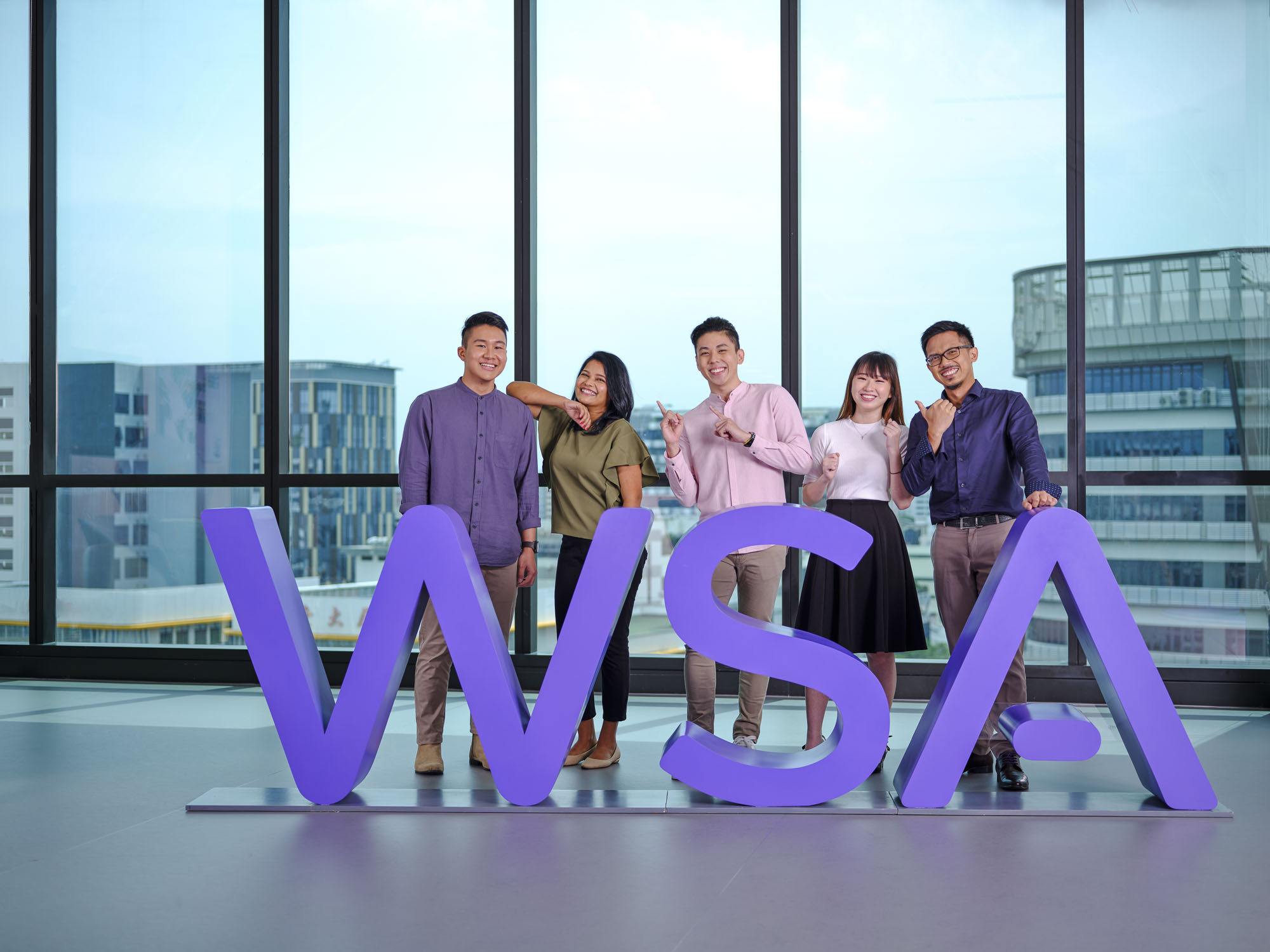 Group shot of company employees in front of WSA logo suitable for annual report photography shot by Coco Creative Studio Singapore