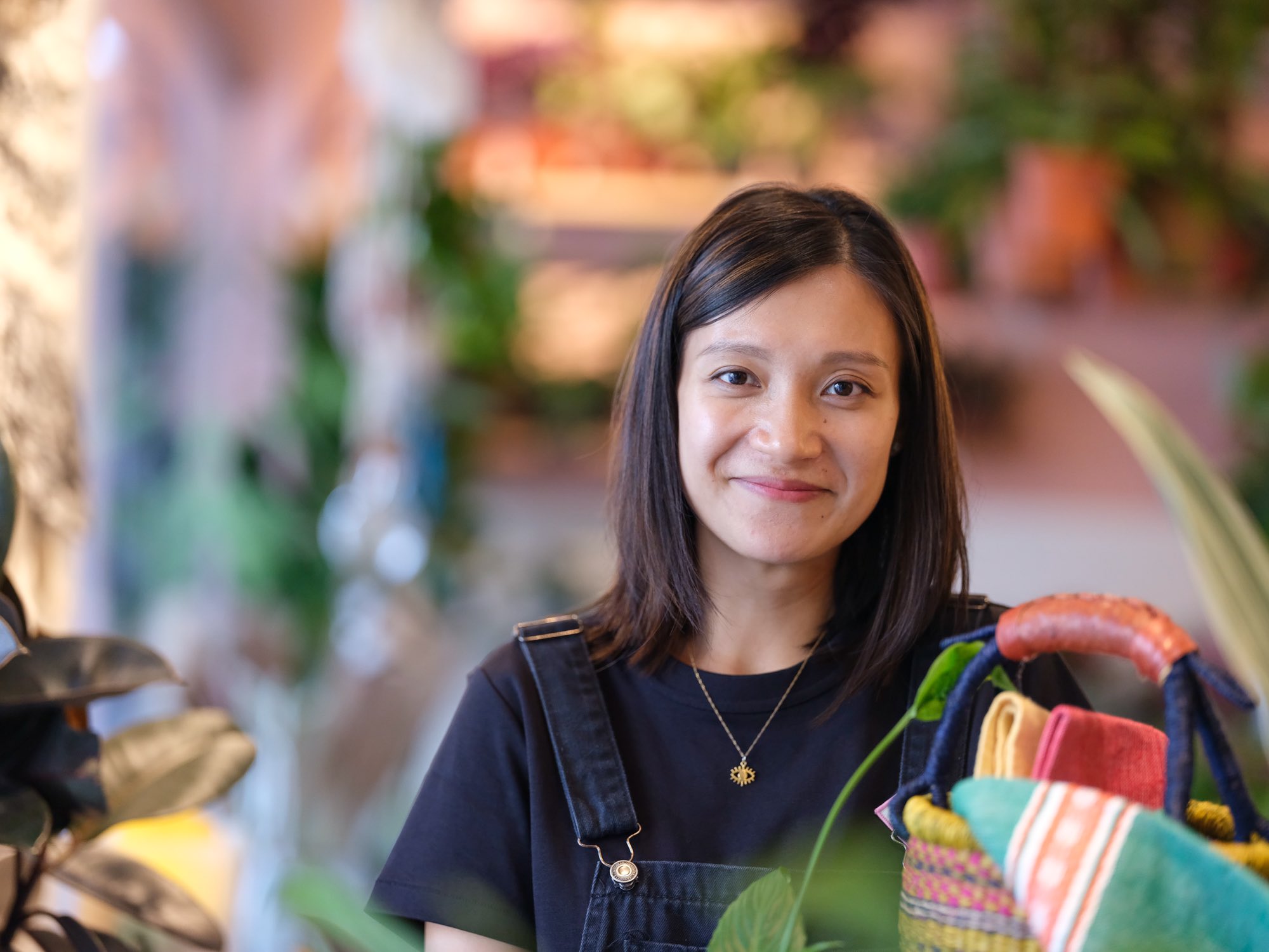 woman in apron working in plant store smiling at camera