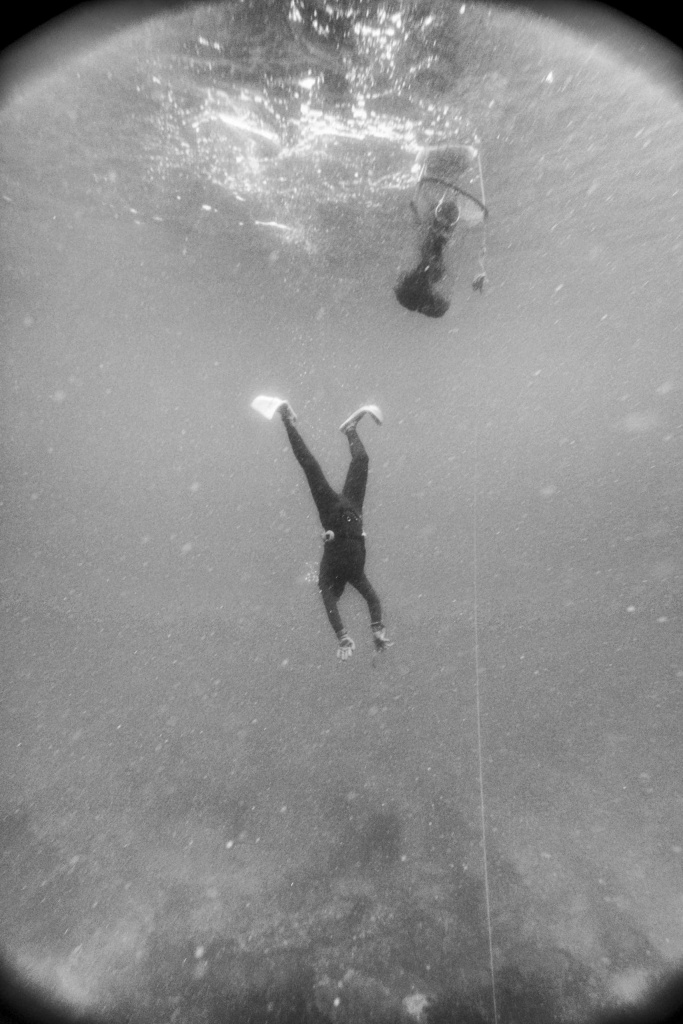 haenyeo, or female diver, mid-descent diving to the ocean floor, shot in black and white