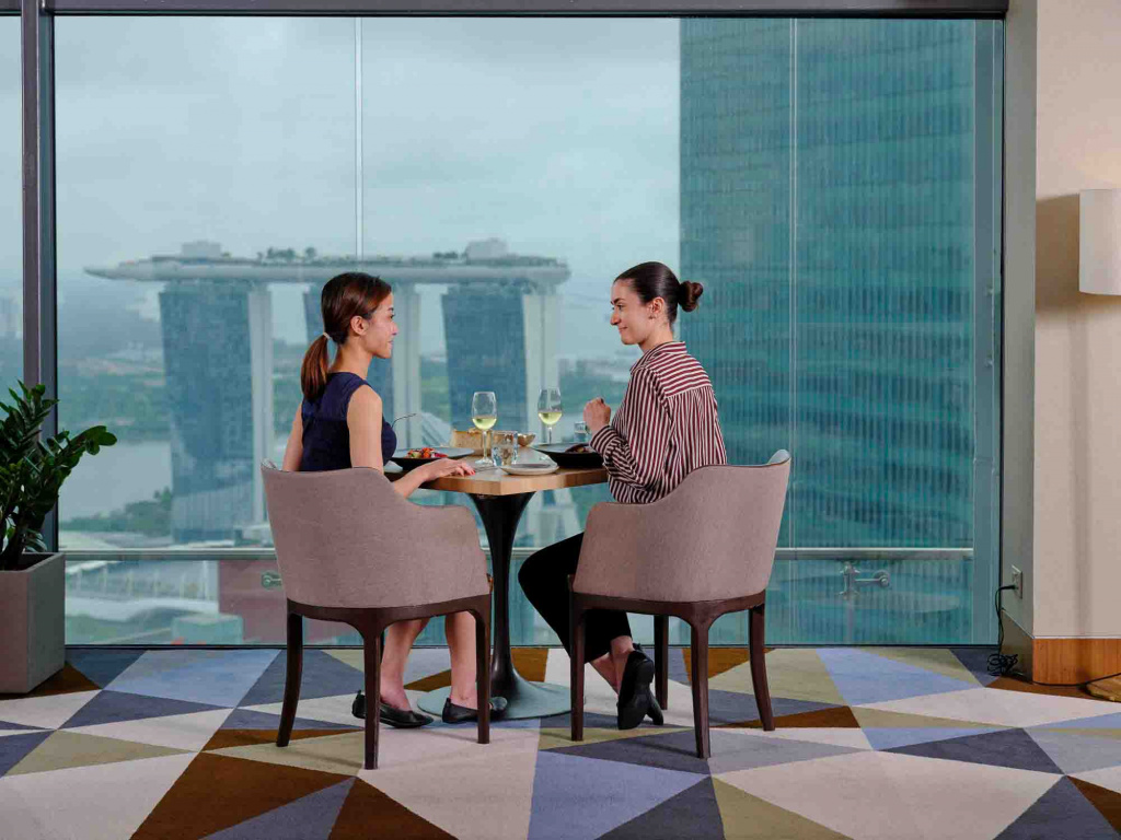 2 ladies enjoying food and wine at a side table in Artemis Restaurant