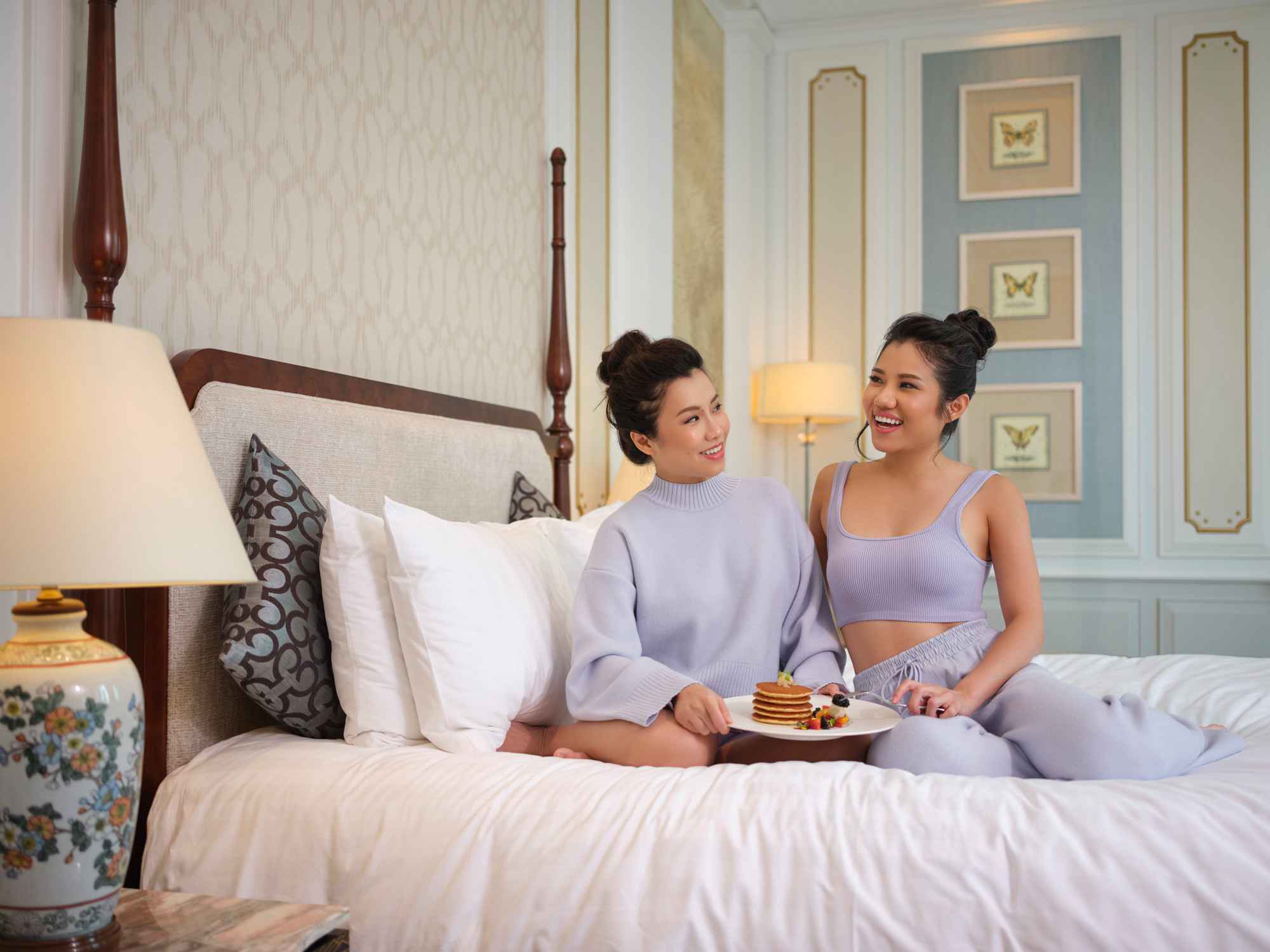 2 ladies relaxing on the bed with pancakes in Intercontinental Hotel photography