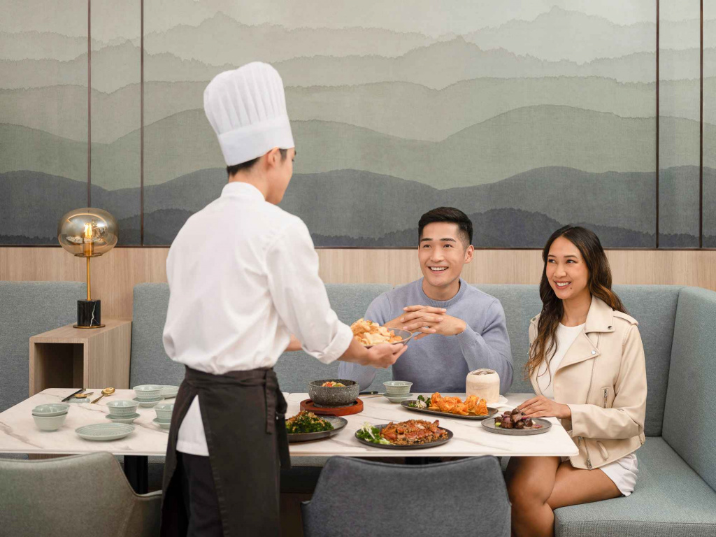 Couple enjoying a meal while the chef brings in food at Orchid hotel, photo taken by coco creative studio lifestyle shootOrchid-lifestyle-interior-hospitality-photgraphy-coco-creative-studio-singapore-france