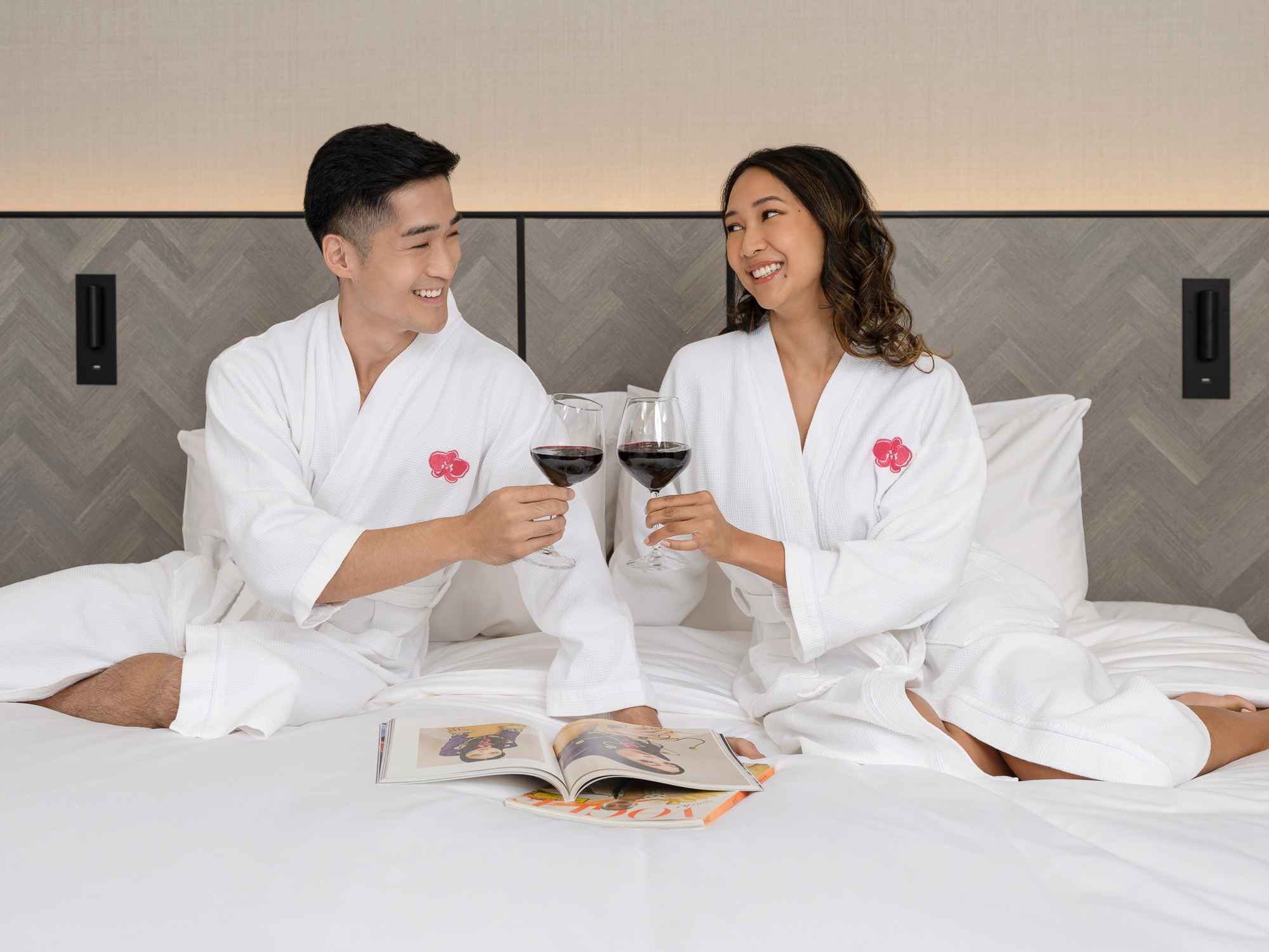 Couple cheers in bed at orchid hotel, photo taken by coco creative studio lifestyle shoot
