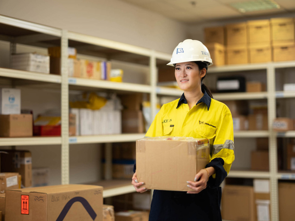 Wihelmson Industrial Photography - lady in safety outfit carrying a box