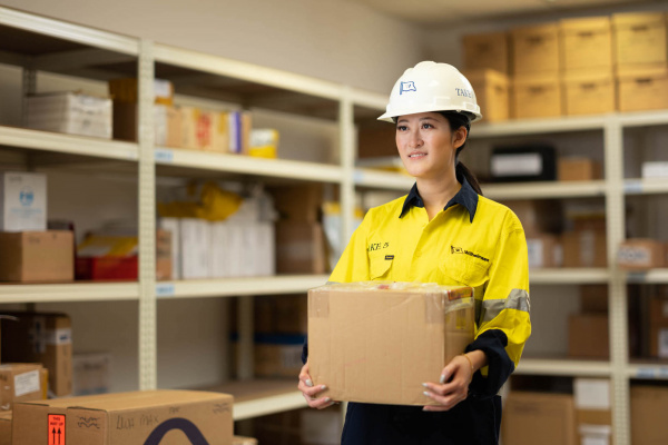 Wihelmson Industrial Photography - lady in safety outfit carrying a box