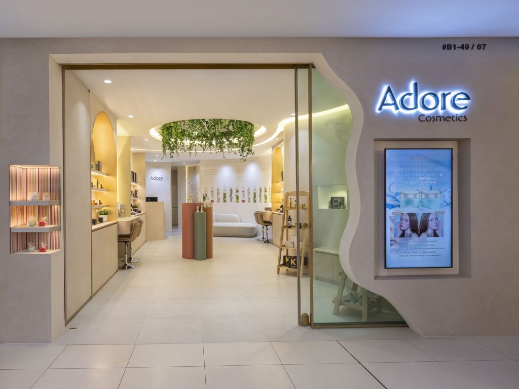 photos of Adore's cosmetics boutique in Singapore. Several products can be seen, as well as a place to sit and have your make-up done.
