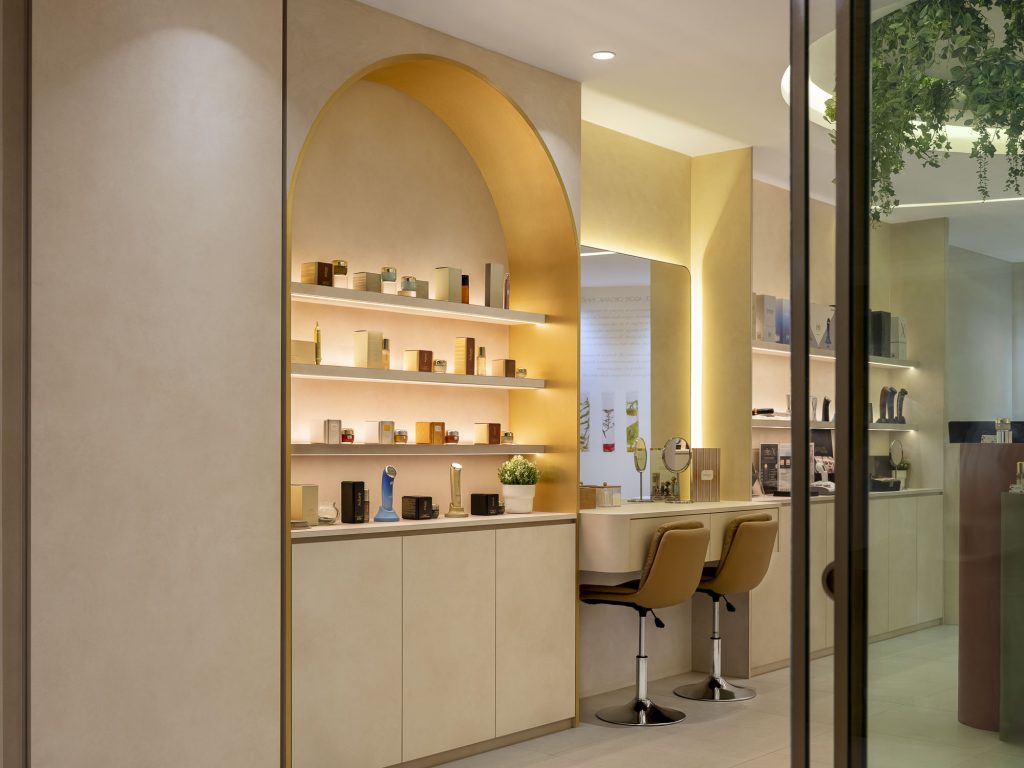photos of Adore's cosmetics boutique in Singapore. Several products can be seen, as well as a place to sit and have your make-up done.