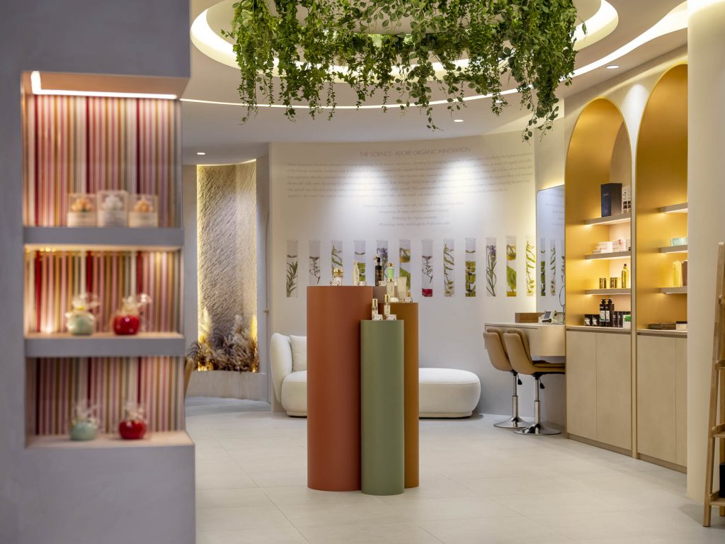 photos of Adore's cosmetics boutique in Singapore. Several products can be seen, as well as a place to sit and have your make-up done.