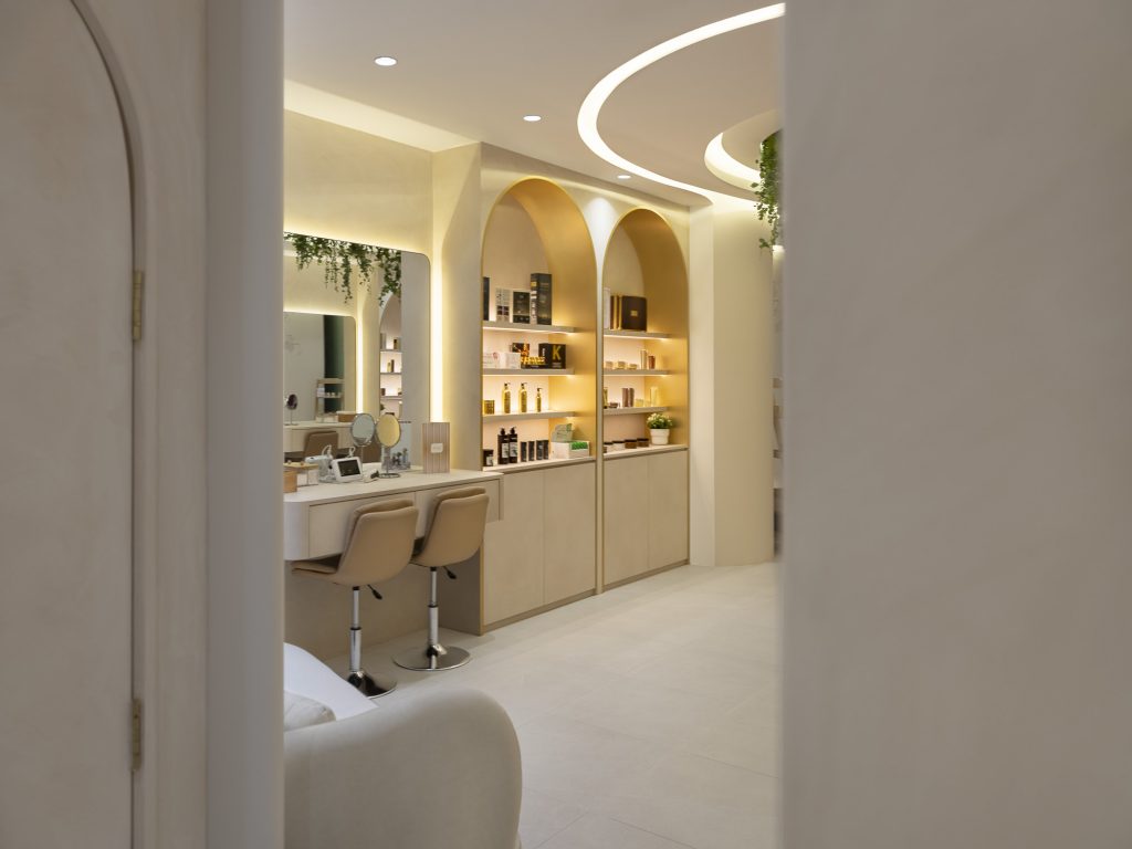 photos of Adore's cosmetics boutique in Singapore. Several products can be seen, as well as a place to sit and have your make-up done.