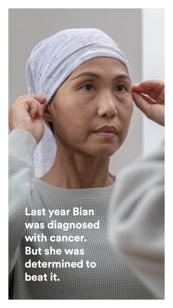 A woman dressed in a hospital gown, determined to beat her cancer