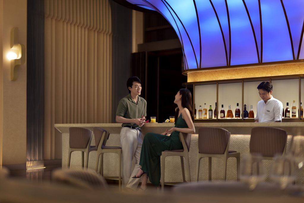 Hotel resort lifestyle photographer Hilton China Asia commercial - Couple looking at each other. The man stands and the woman sits