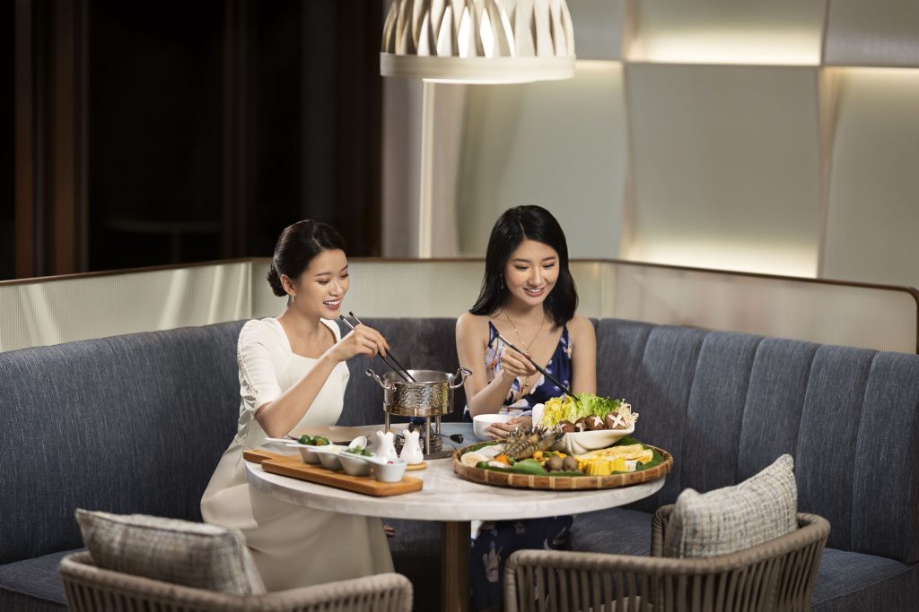 Hotel resort lifestyle photographer Hilton China Asia commercial - Two friends are having dinner in the hotel restaurant