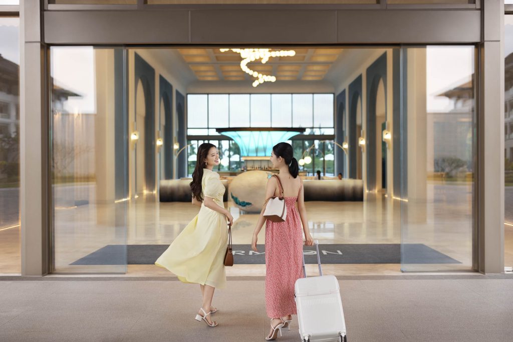 Hotel resort lifestyle photographer Hilton China Asia commercial - Two clients walking in the lobby of the hotel. One has a luggage. They are smiling