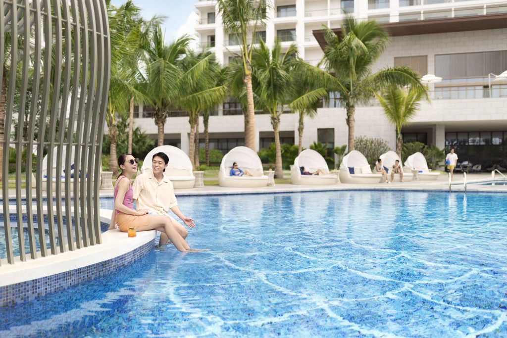 Hotel resort lifestyle photographer Hilton China Asia commercial - A couple sits near the pool