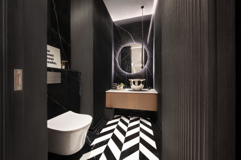 Interior photo of toilet painted all black with tiled floor