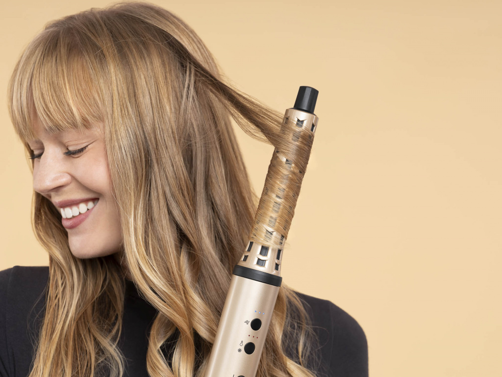 Modèle blonde aux cheveux lisses utilisant le boucleur Demeliss à Paris