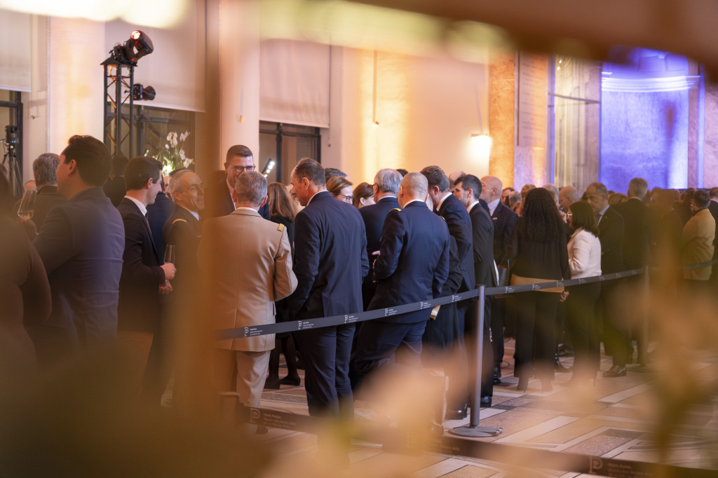 Invités réunis dans le hall du Petit Palais lors des vœux 2025 du MEDEF, photographiés à travers une composition florale en premier plan.