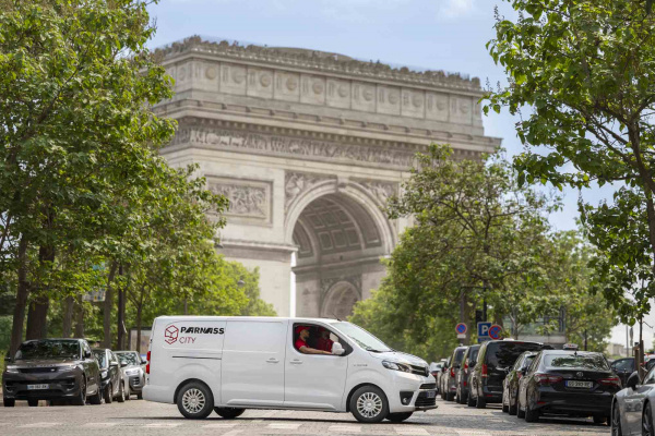 Utilitaire blanc Parnass tourne devant l'Arc de Triomphe