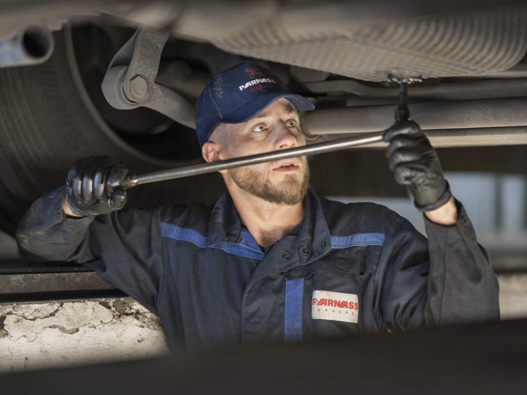 Mecanicien fait la vidange d'un camion Parnass Transport