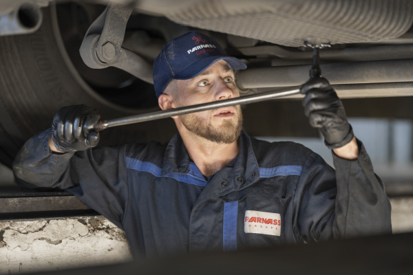 Mecanicien fait la vidange d'un camion Parnass Transport