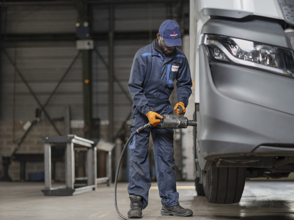 Mecanicien serre les roues d'un camion Parnass transport