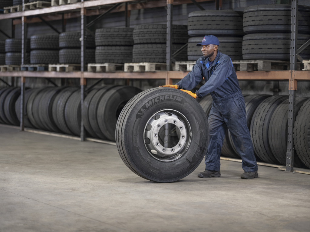 Mecanicien recupere une roue pour mettre sur un camion Parnass Transport