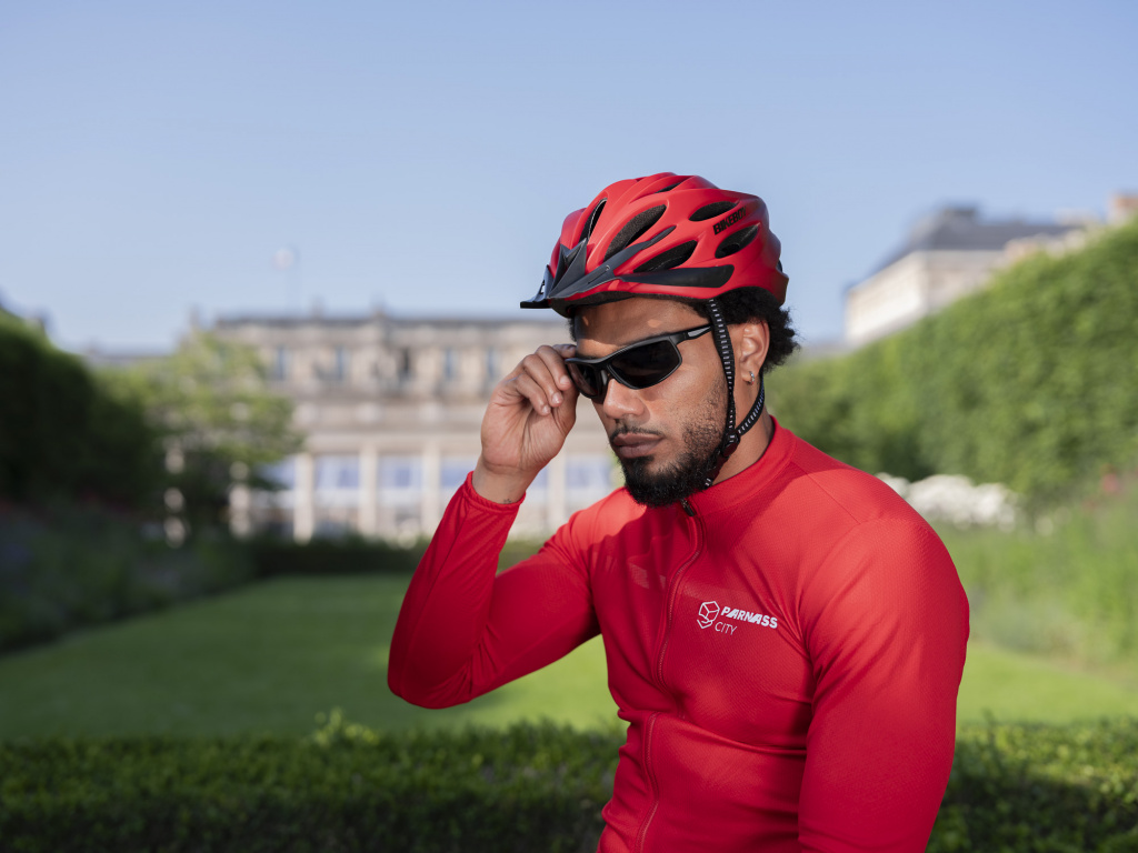 Livreur vélo cargo avec ses lunettes de soleil et son casque, assis sur son vélo cargo