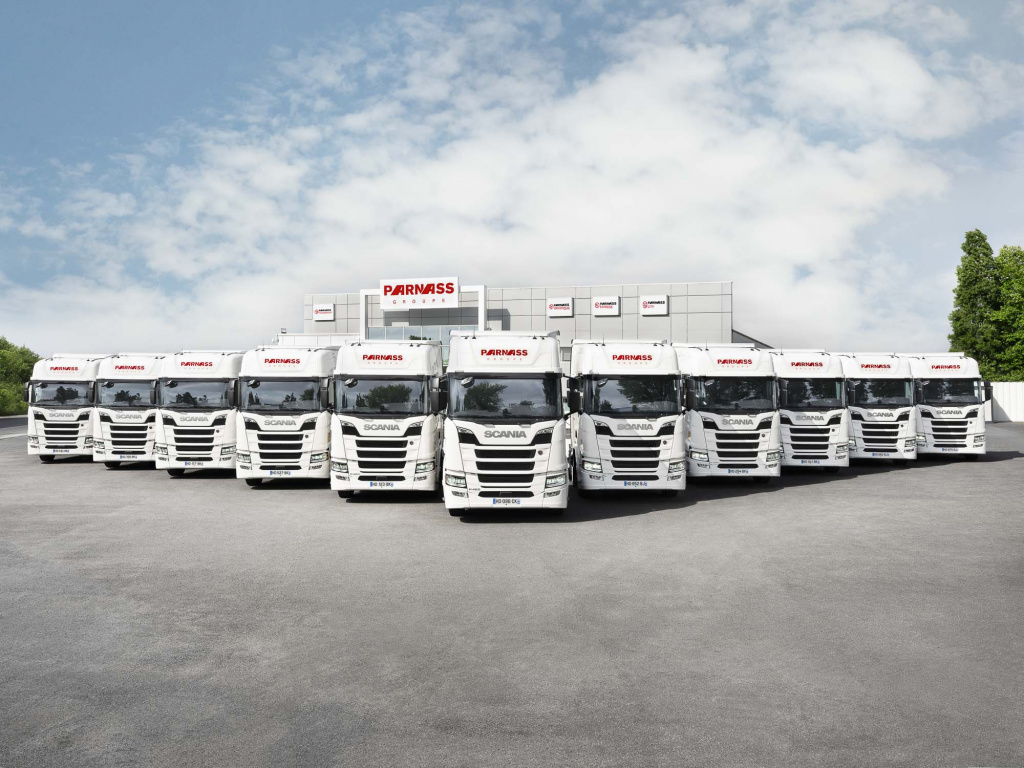 Camions Parnass Transport alignés devant un bâtiment du groupe
