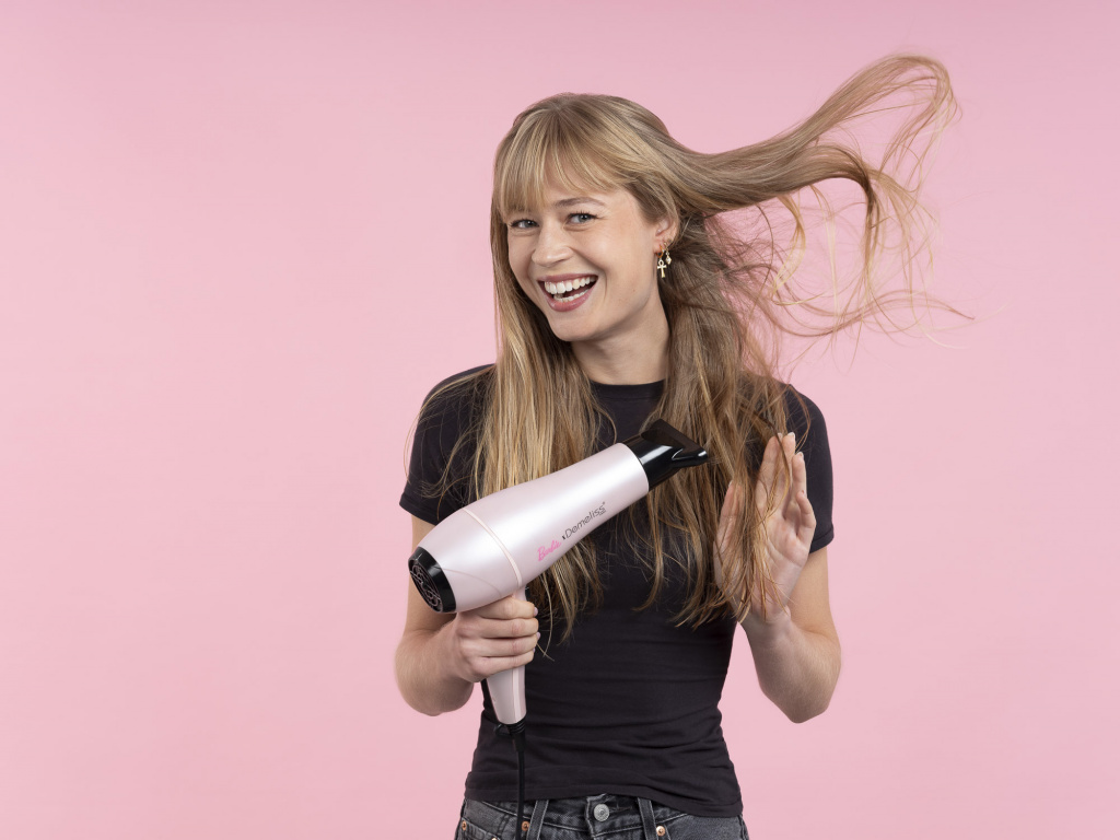 Modèle blonde aux cheveux lisses utilisant le sèche-cheveux Demeliss à Paris